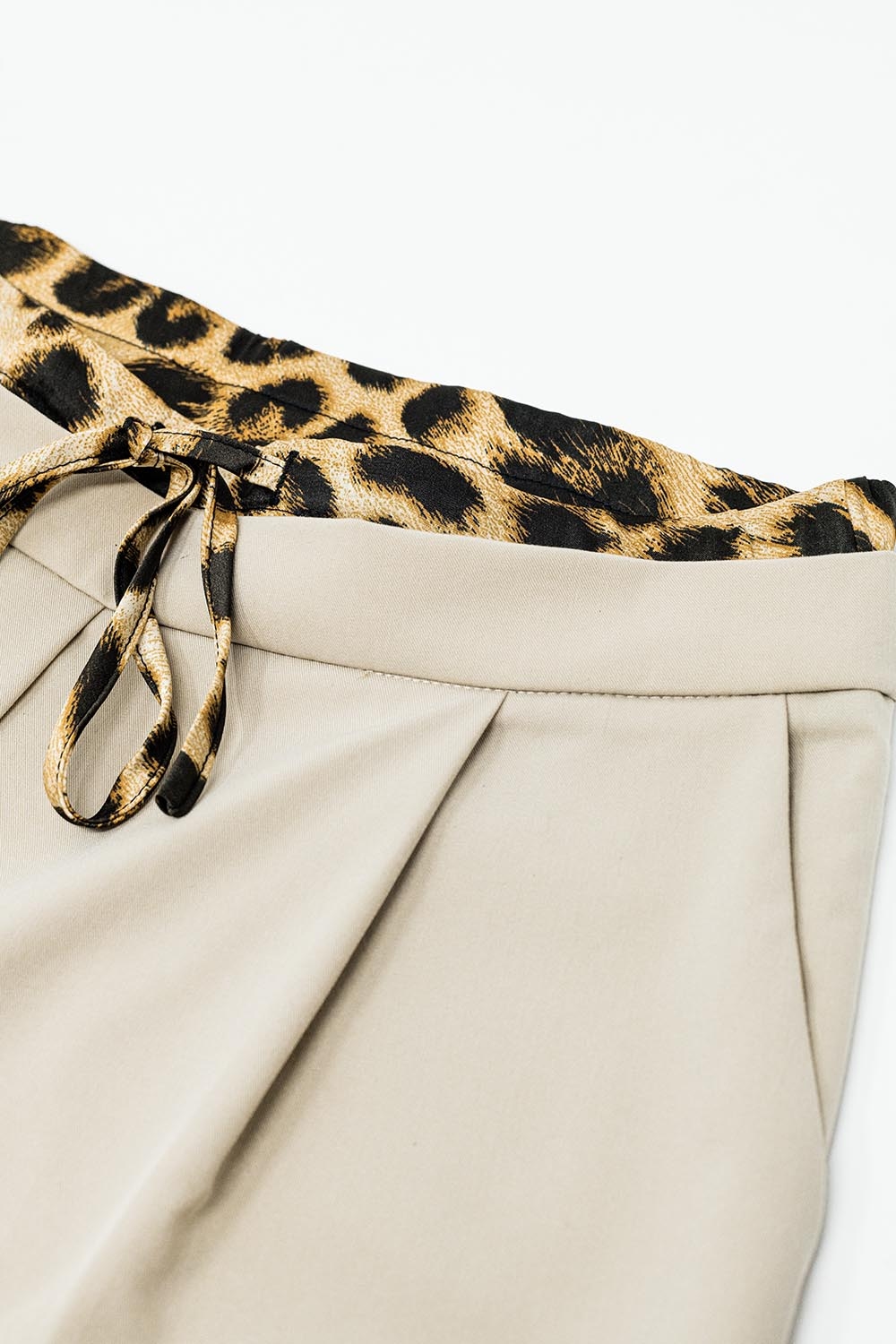 Pantalón largo plisado beige con detalle de leopardo en la cintura Pantalón largo plisado beige con detalle de leopardo en la cintura