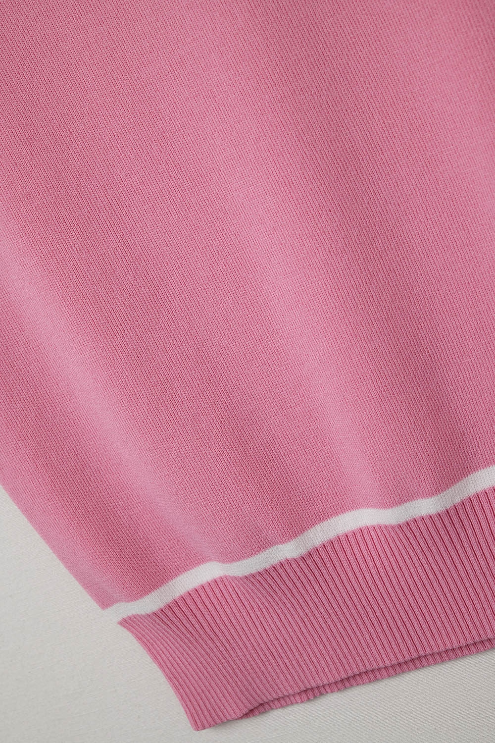 Suéter sin mangas en rosa con líneas blancas de detalle Suéter sin mangas en rosa con líneas blancas de detalle