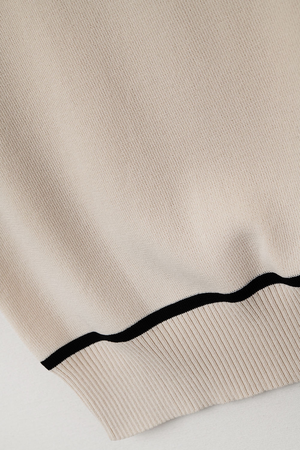 Suéter sin mangas en beige con líneas negras de detalle Suéter sin mangas en beige con líneas negras de detalle