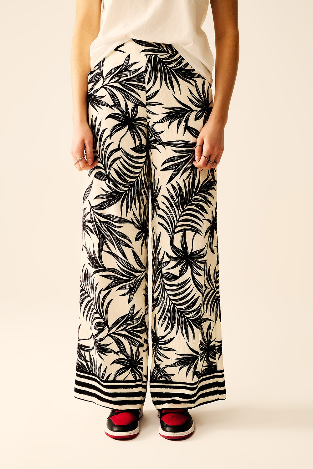 Pantalones de pierna ancha en blanco con detalle floral en negro Pantalones de pierna ancha en blanco con detalle floral en negro