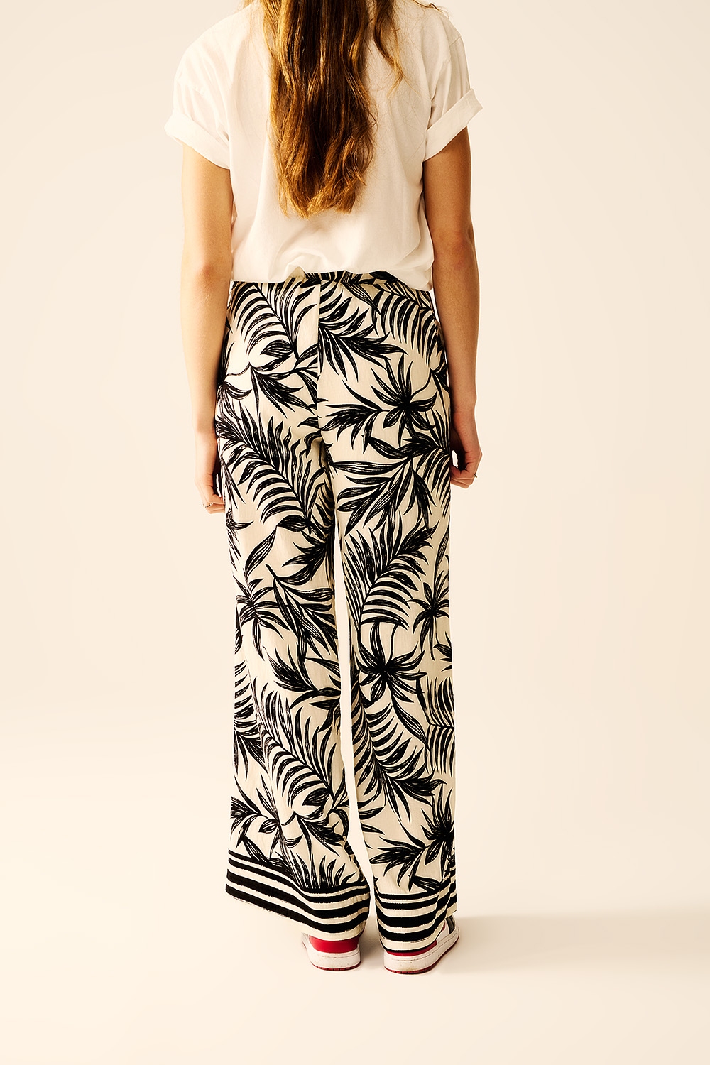 Pantalones de pierna ancha en blanco con detalle floral en negro Pantalones de pierna ancha en blanco con detalle floral en negro