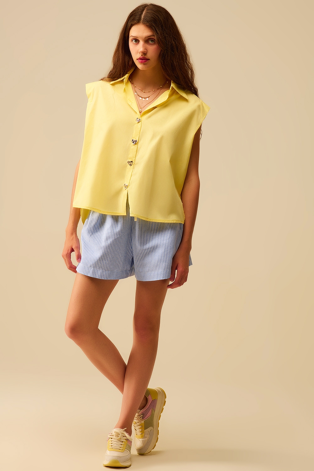 Blusa amarilla sin mangas con botones en forma de coraz&oacute;n