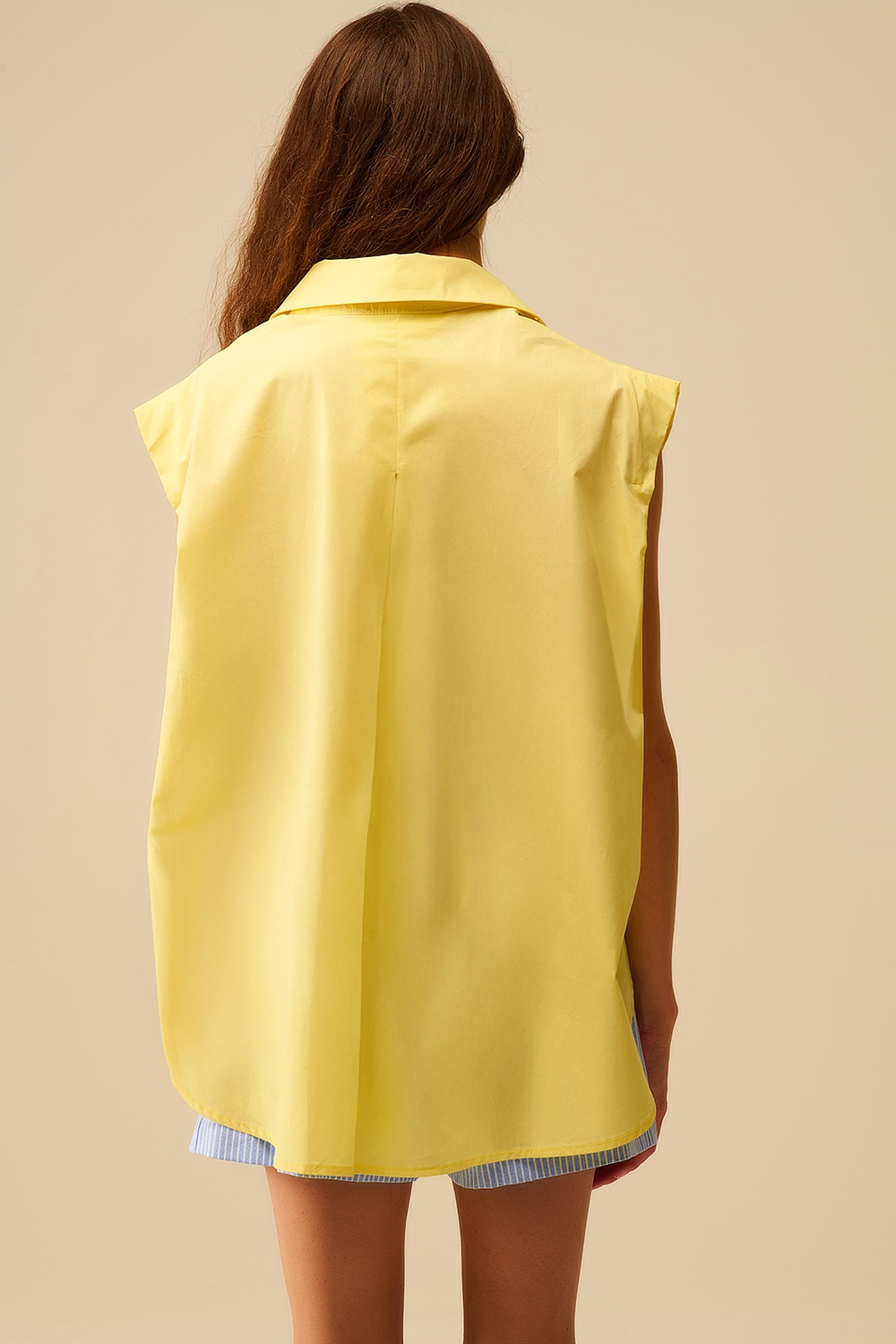 Blusa amarilla sin mangas con botones en forma de coraz&oacute;n