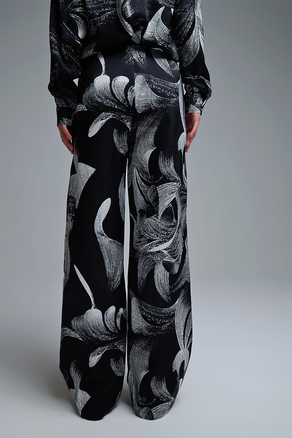 Elegante pantalón negro estampado de pata ancha en tejido satinado Elegante pantalón negro estampado de pata ancha en tejido satinado