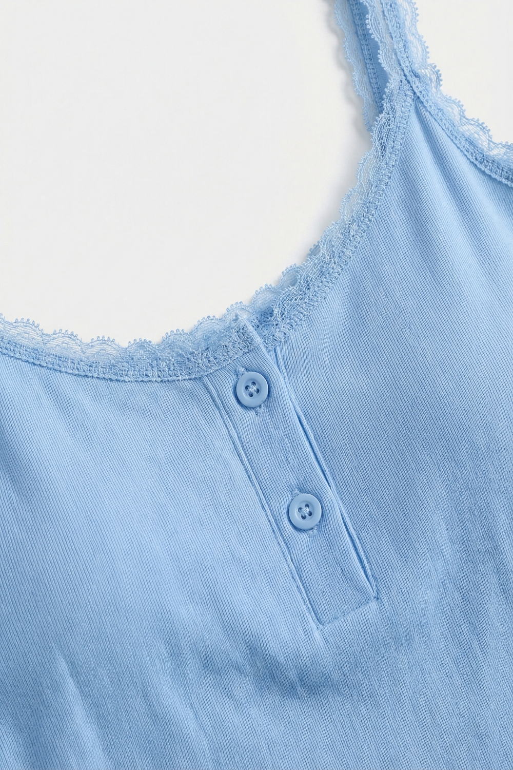 Top corto de punto acanalado azul claro con detalles de botones