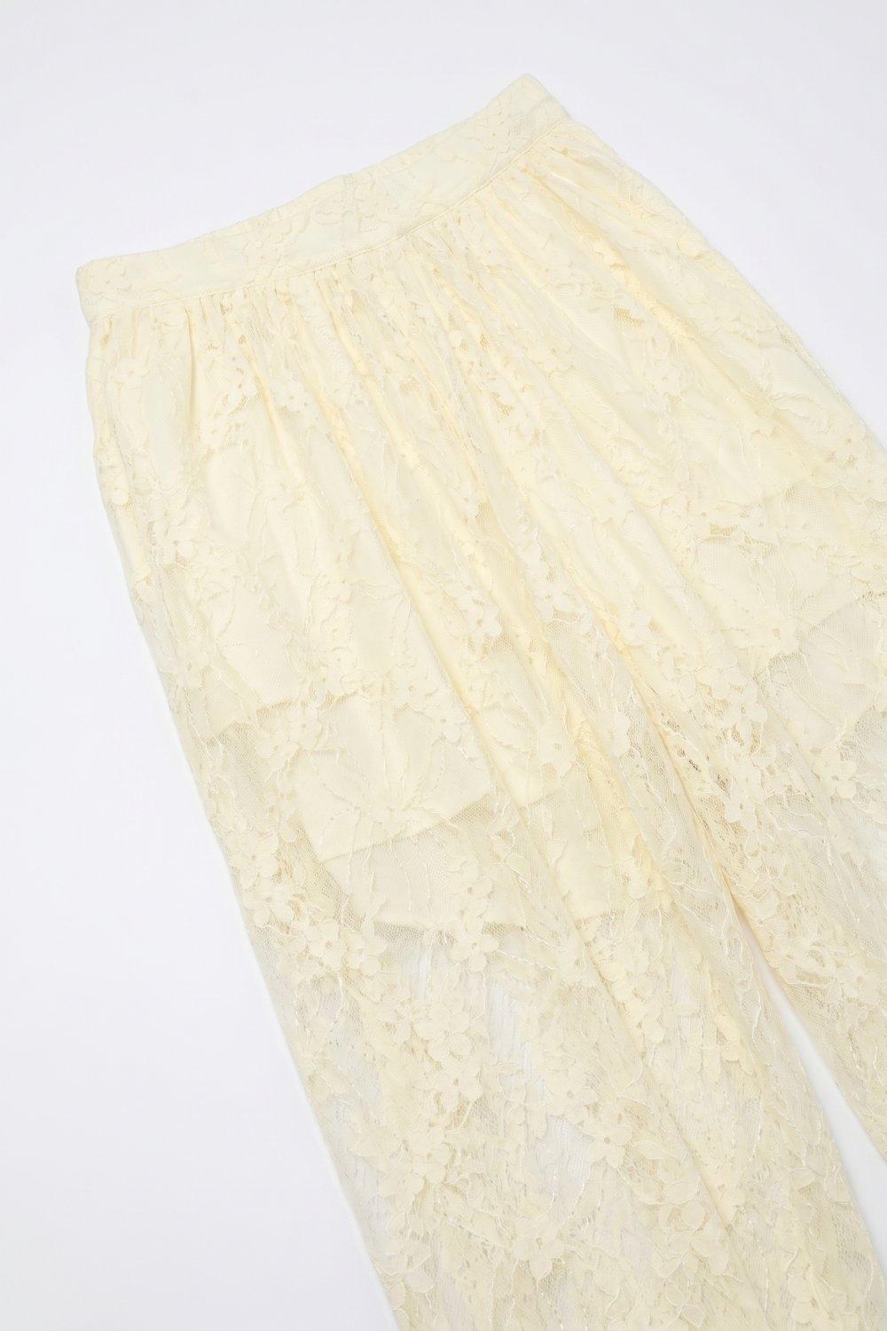Pantalones de corte relajado con encaje floral color crema y bajo con lazo