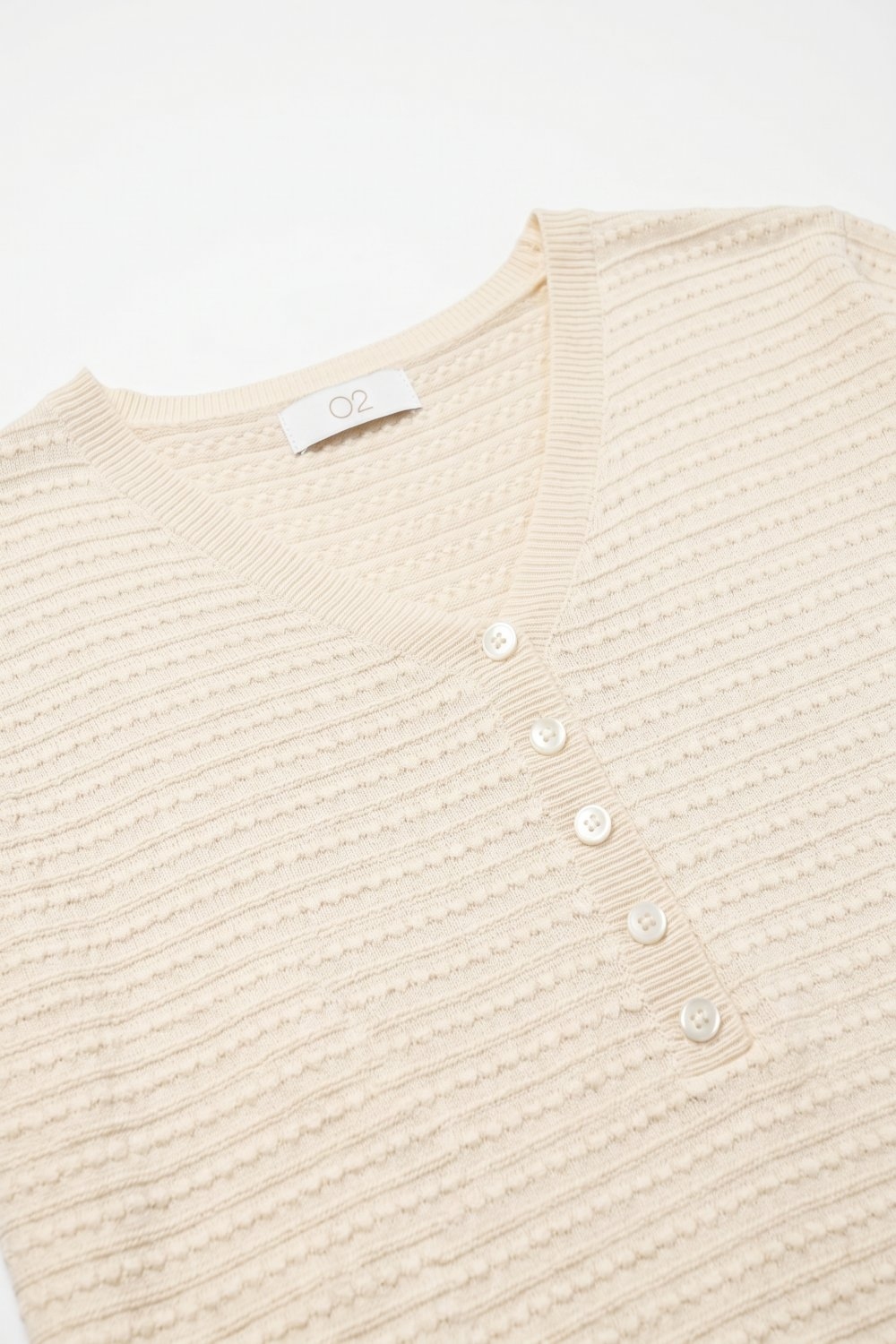 Su&eacute;ter de manga corta con detalle de botones y tejido de punto fino texturizado en beige