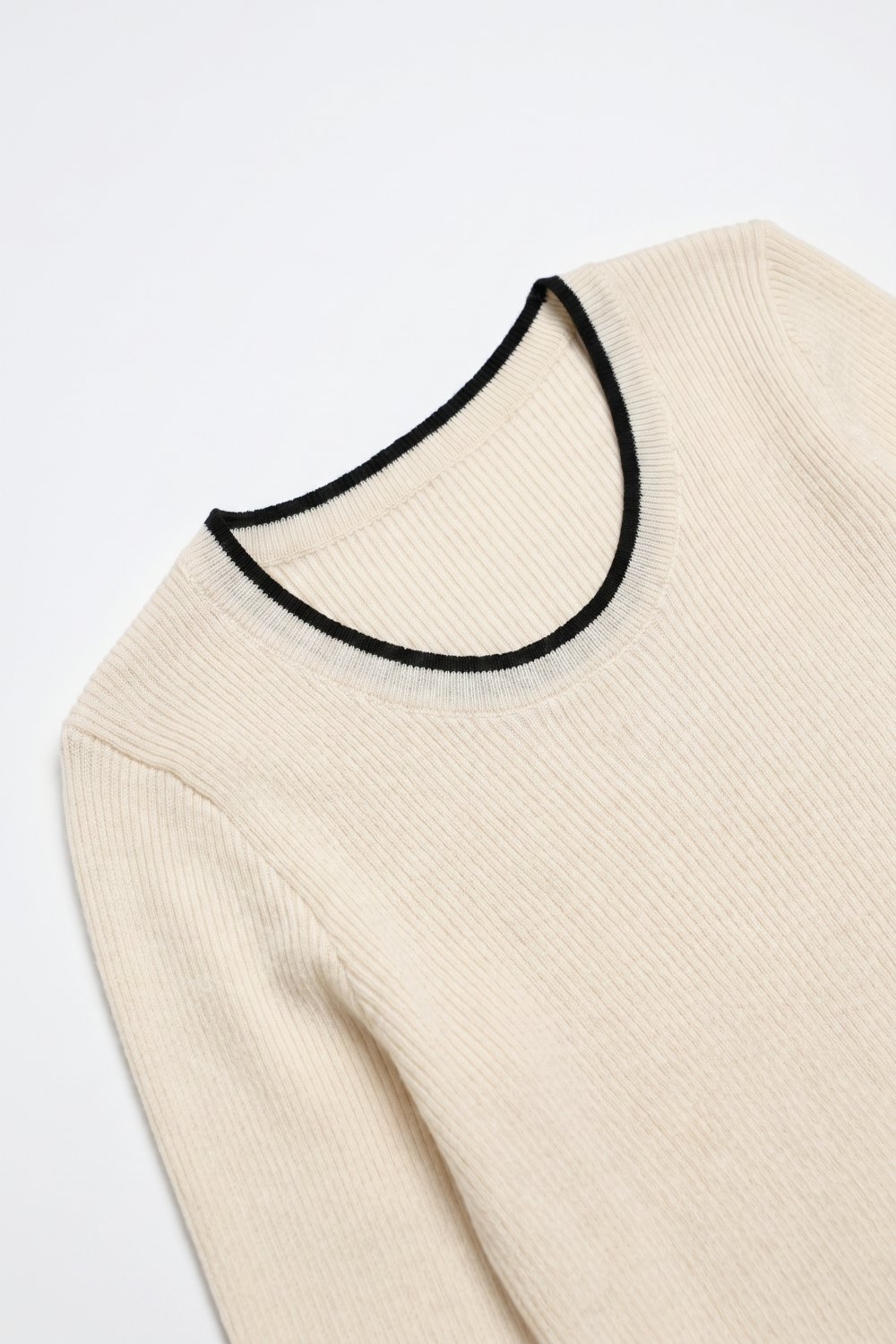 Su&eacute;ter de punto acanalado crema con contraste negro en el cuello ancho