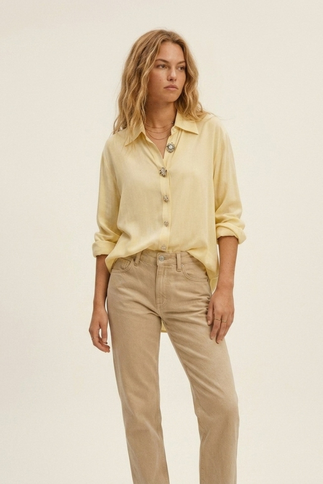 Blusa amarilla mantequilla adornada con botones.