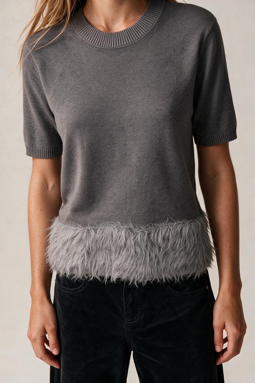 Suéter gris de punto fino con dobladillo de plumas y mangas cortas Suéter gris de punto fino con dobladillo de plumas y mangas cortas