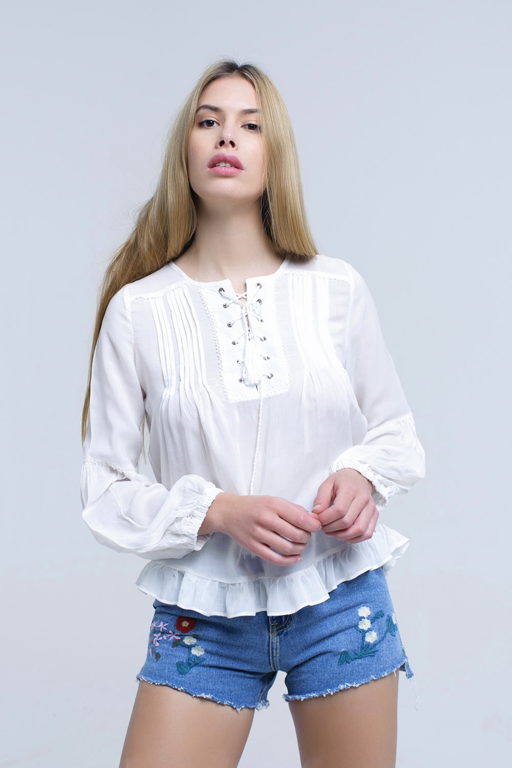 Top blanco con detalle anudado y bajo con volante
