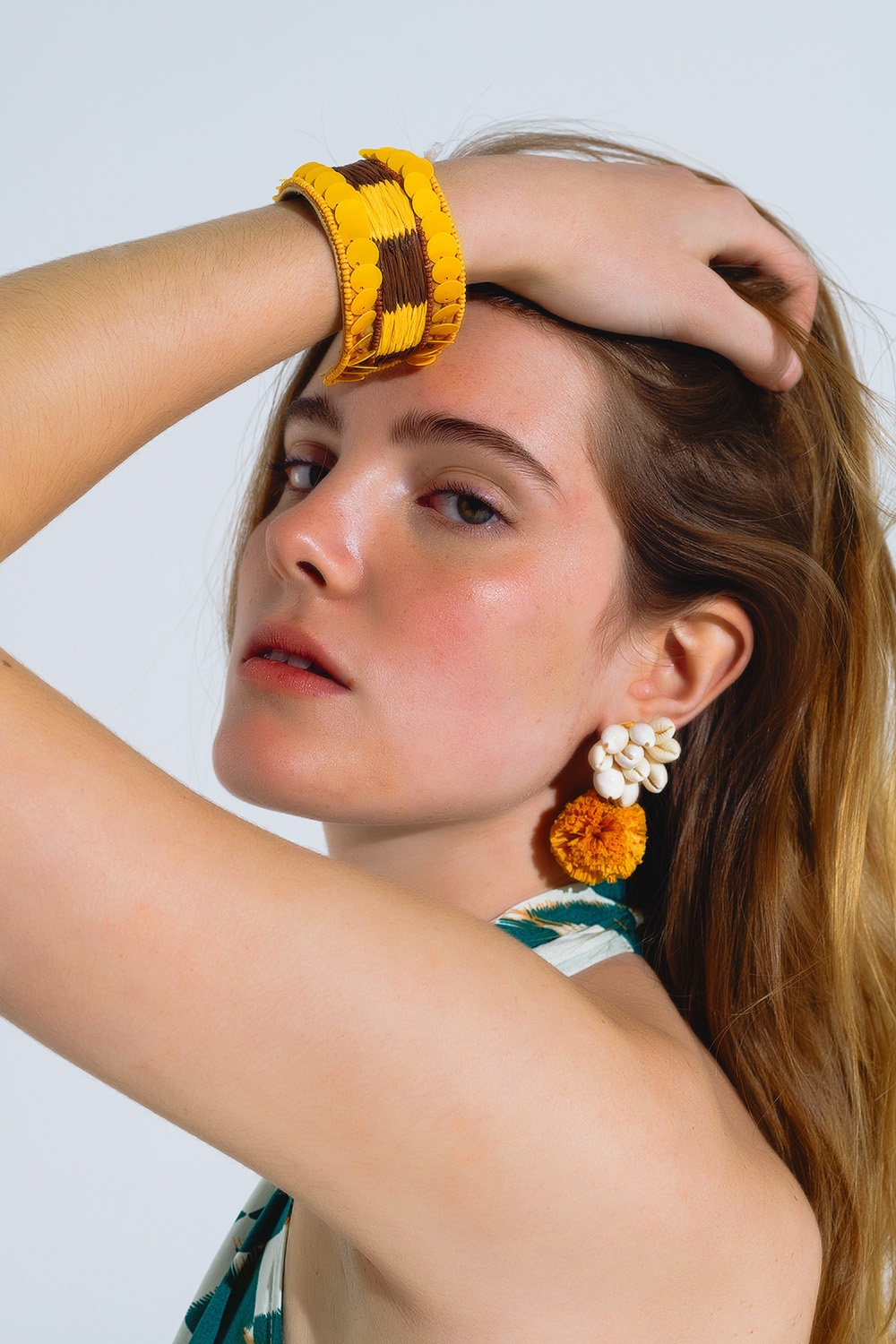 Pendientes con conchas de mar color crema y pompones amarillos