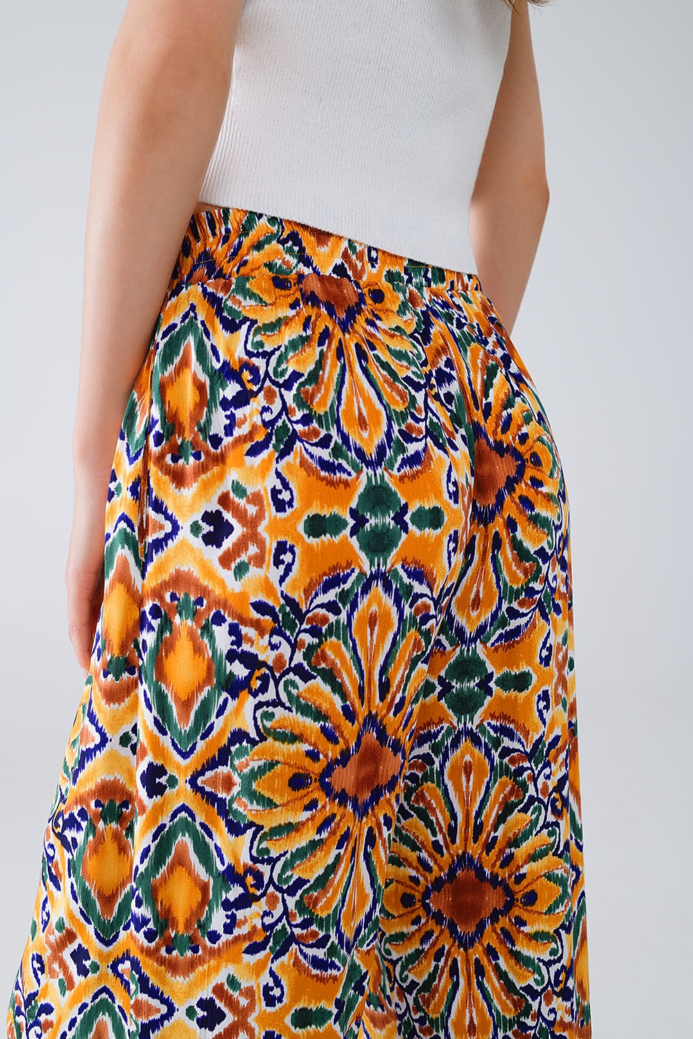 Pantalones multicolores con estampado de flores en naranja y azul Pantalones multicolores con estampado de flores en naranja y azul