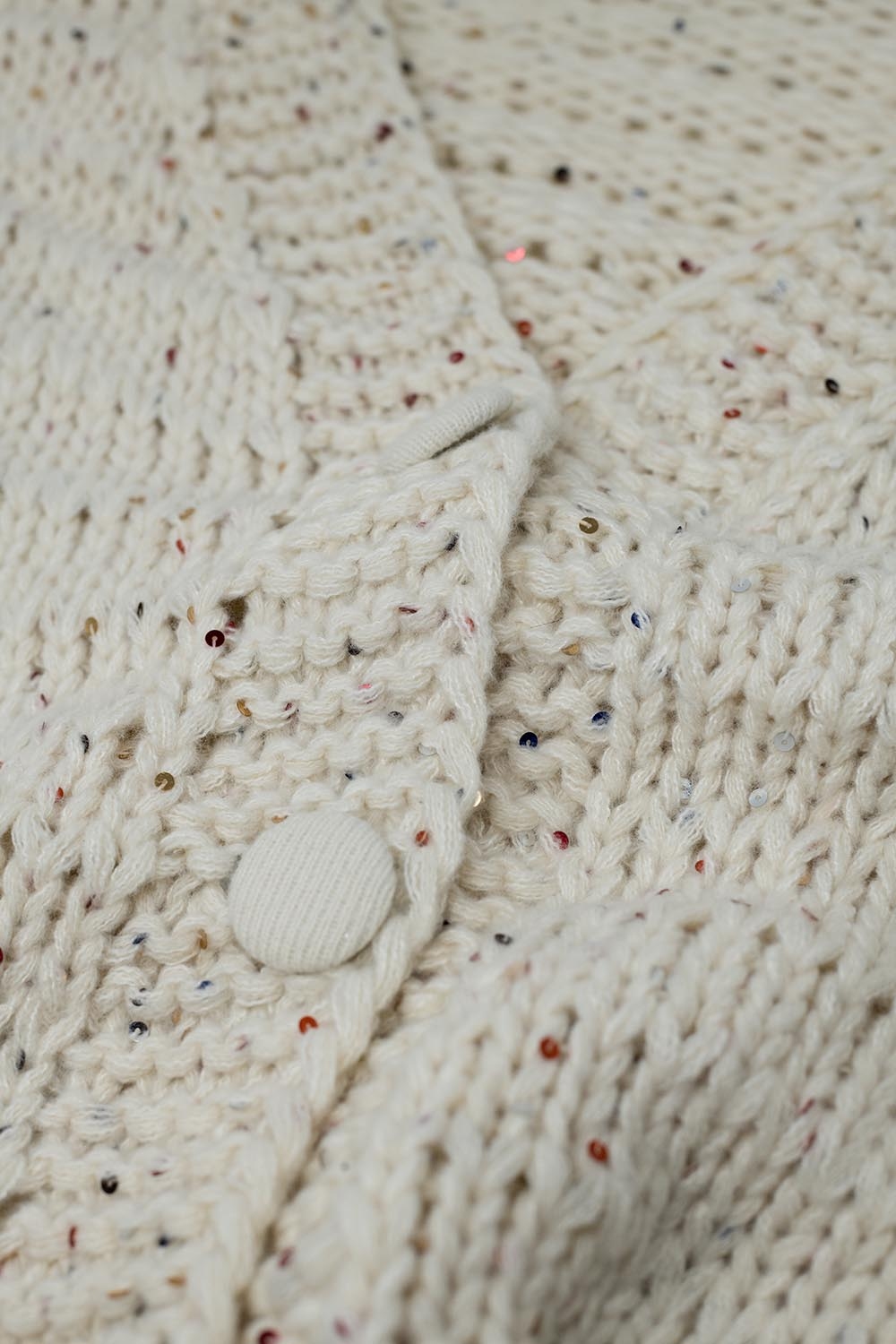 Chaqueta oversize de punto grueso en color crema con detalle de lentejuelas
